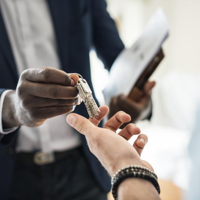 Real estate agent handing the house key to a client